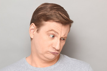 Obraz premium Portrait of mature man with unhappy sad resentful expression on face