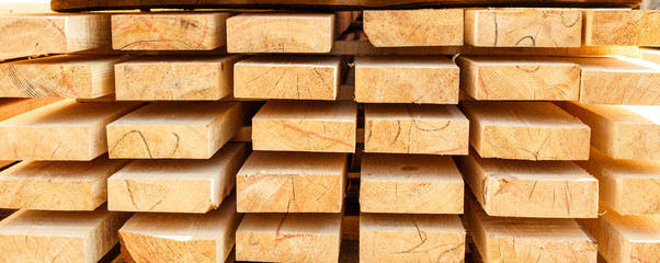 Stack of new wooden studs at the lumber yard. Timber on the construction site to dry. Background of...