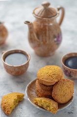 Homemade gluten-free cornmeal cookies on a light table along with a coffee set