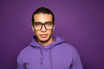 Smart intelligent young handsome man wearing eyeglasses standing isolated over purple background....