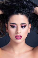 A young woman artistic portrait with a beautiful make up and curly hair