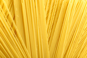 Long yellow spaghetti pasta food ingredient. Uncooked dry macaroni. Thin raw noodle. Cereal wheat product for delicious gourmet cooking. A useful source of carbohydrates. Healthy italian pasta.