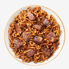 Ram-Don or Chapaguri noodles with beef steak in bowl isolated on white background. Jjapaguri is a popular south korean dish with ramen and udon noodles and beef steak.