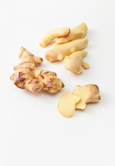Cut and peeled young ginger root on a white background