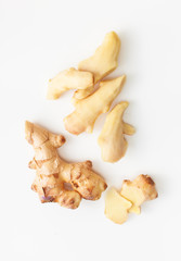 Cut and peeled young ginger root on a white background