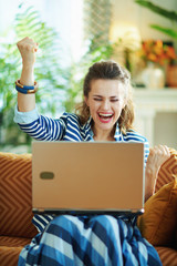 happy female with laptop and with open arms rejoicing