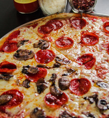 Pizza de pepperoni con mitad de champiñones 