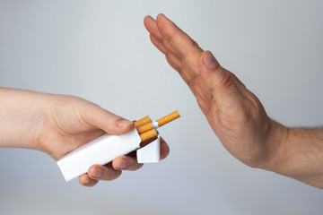 Giving up cigarettes. The girl hands the cigarettes in a pack to the man, the man refuses.