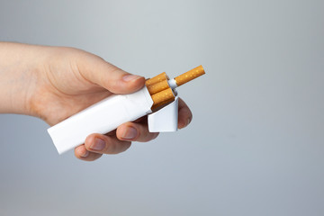 Woman hand with box of cigarettes. White background