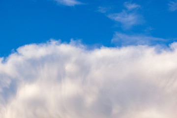 plumose clouds of the top tier in blue space of the sky