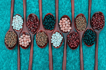 Collection of bean in wooden spoons .dried legumes in wooden spoons place on the table  