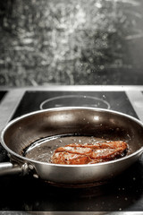 cooking chicken in a pan in the kitchen
