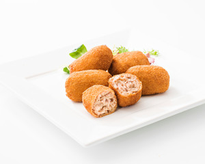 Tasty cut croquettes on square plate