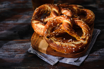Obraz na płótnie Canvas Freshly baked homemade soft pretzel with salt on wooden table. Perfect for Octoberfest.