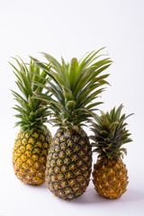 Ripe Pineapples Of Different Sizes Against White Background