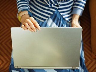 woman closing laptop while sitting on couch