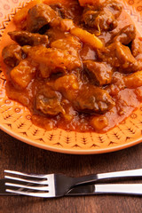 plate with cooked cassava and meat on wooden table