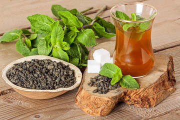 Moroccan tea with mint and sugar in a glasses on wooden background