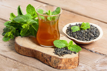 Moroccan tea with mint and sugar in a glasses on wooden background
