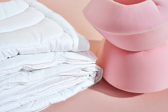 Folded comforter next to pink foam shapes