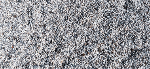 White small pebbles or decorative gravel. Natural daylight. The