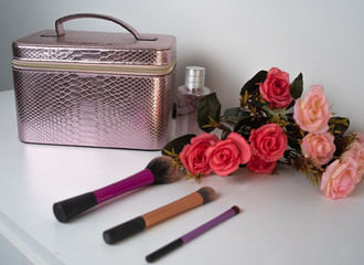 Obraz na płótnie Canvas makeup bag on the table with flowers