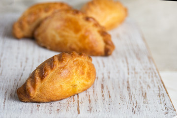 Delicious homemade mini pies on a white background. Baking from yeast dough. Traditional eastern Slavic cuisine.