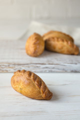 Delicious homemade mini pies on a white background. Baking from yeast dough. Traditional eastern Slavic cuisine.