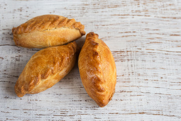 Delicious homemade mini pies on a white background. Baking from yeast dough. Traditional eastern Slavic cuisine.