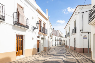 a cobbled street with typical white houses in Olivença (Olivenza) town, province of Badajoz, Extremadura, Portugal/Spain