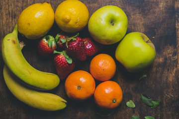 Mix of delicious fruits on the rustic wood table. Perfect mix of colours. Nice to make a salad fruit.