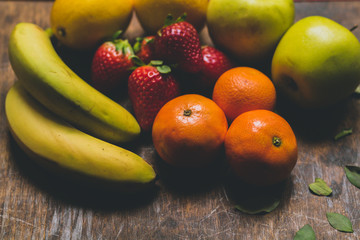 Mix of delicious fruits on the rustic wood table. Perfect mix of colours. Nice to make a salad fruit.