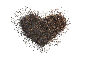 Heart shape made from black sesame seeds on a white isolated background.