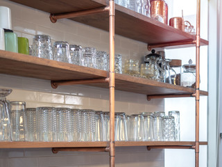 Drinking glass shelf made from copper pipes and wooden plate.