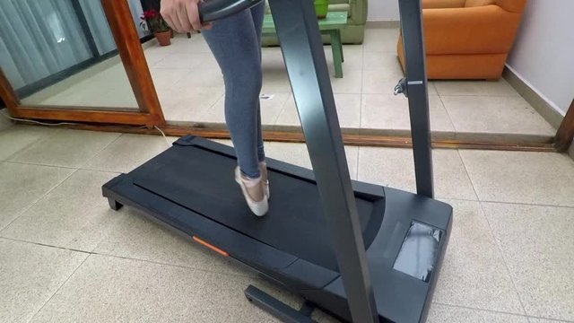 Detail of the legs of a ballerina with ballet shoes on a treadmill at home
