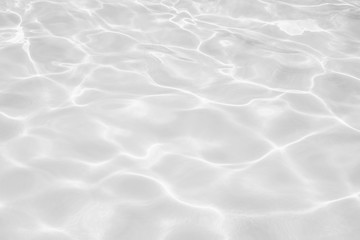 Fototapeta na wymiar Closeup of desaturated transparent clear calm water surface texture with splashes and bubbles. Trendy abstract nature background. 