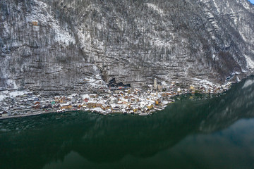 Aerial drone shot of Hallstatt village covered by snow during winter time in Austria
