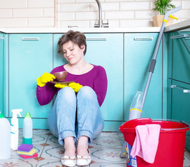 Mams home quarantine concept. A smiling young Caucasian woman in rubber gloves among detergents and...