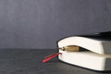 close up of notepad with pen on tiles background 