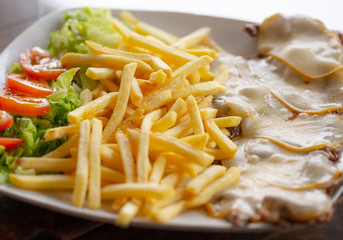 Grilled steak with cheese on top, ready to eat.