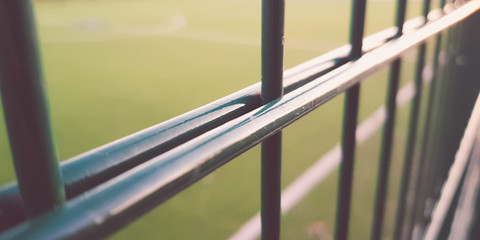 lawn field for playing minifootball behind the green fence mesh closeup