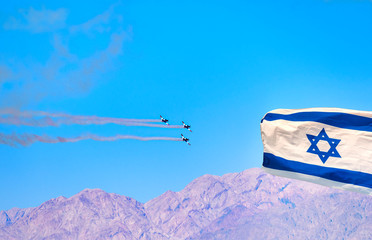 Streaming Israeli Flag and Air Acrobatic flight reciprocating aircraft Israeli group showing flying skills on the Parade of Independence Day of Israel
