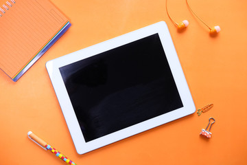 top view of digital tablet with blank screen on orange background 