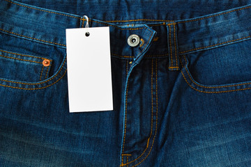 Closeup of blue jeans with white blank for price tag or your text.