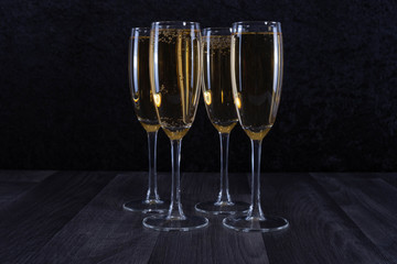 four glasses filled with champagne to the brim