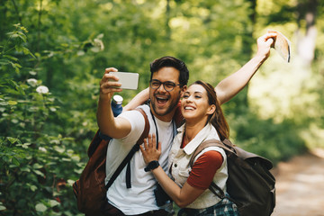 Hiker couple smiling for the camera to take a selfie