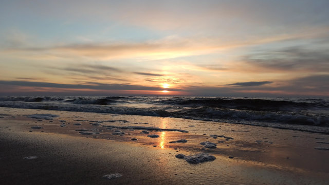 Beautiful Sunrise Over Batlic Sea With Majestic Sky Light Being Reflected. Waves Slowly Rolling in on the Beach. Vecaki beach Riga, Latvia.