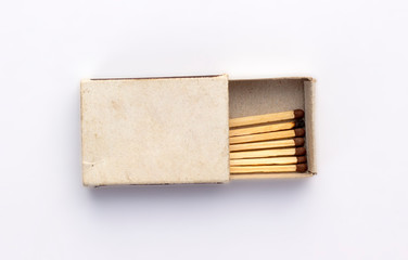 Opened old box of matches isolated on white background, top view. One burnt wooden match among the...