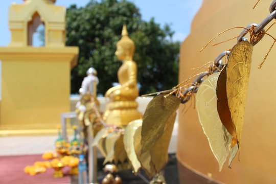 Golden prayer leafs in front of a buddha