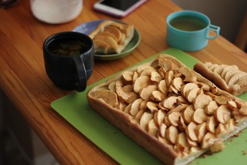 Baking a homemade apple pie and eating breakfast with tea at the cozy kitchen